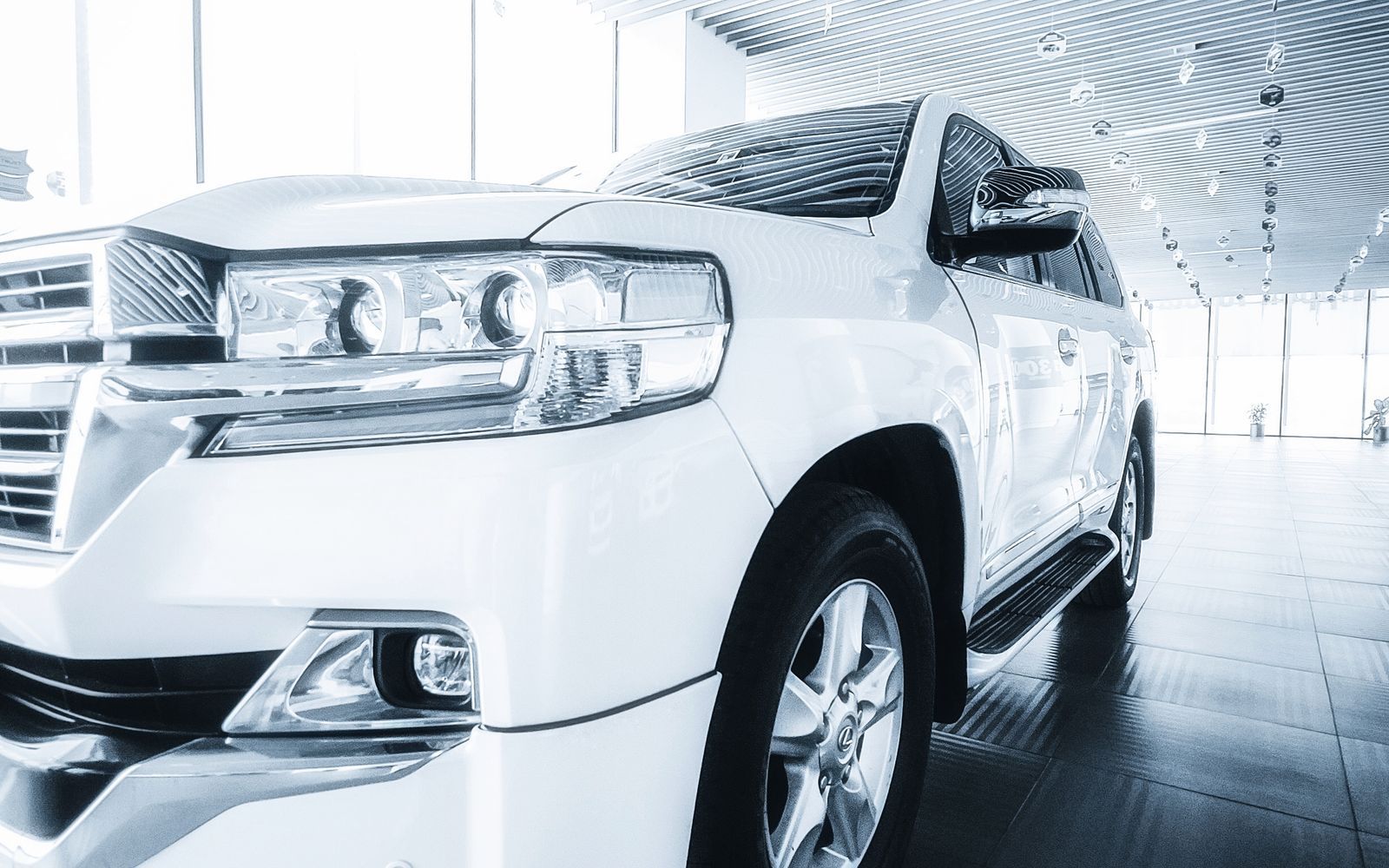 White SUV displayed on a polished dealership showroom floor