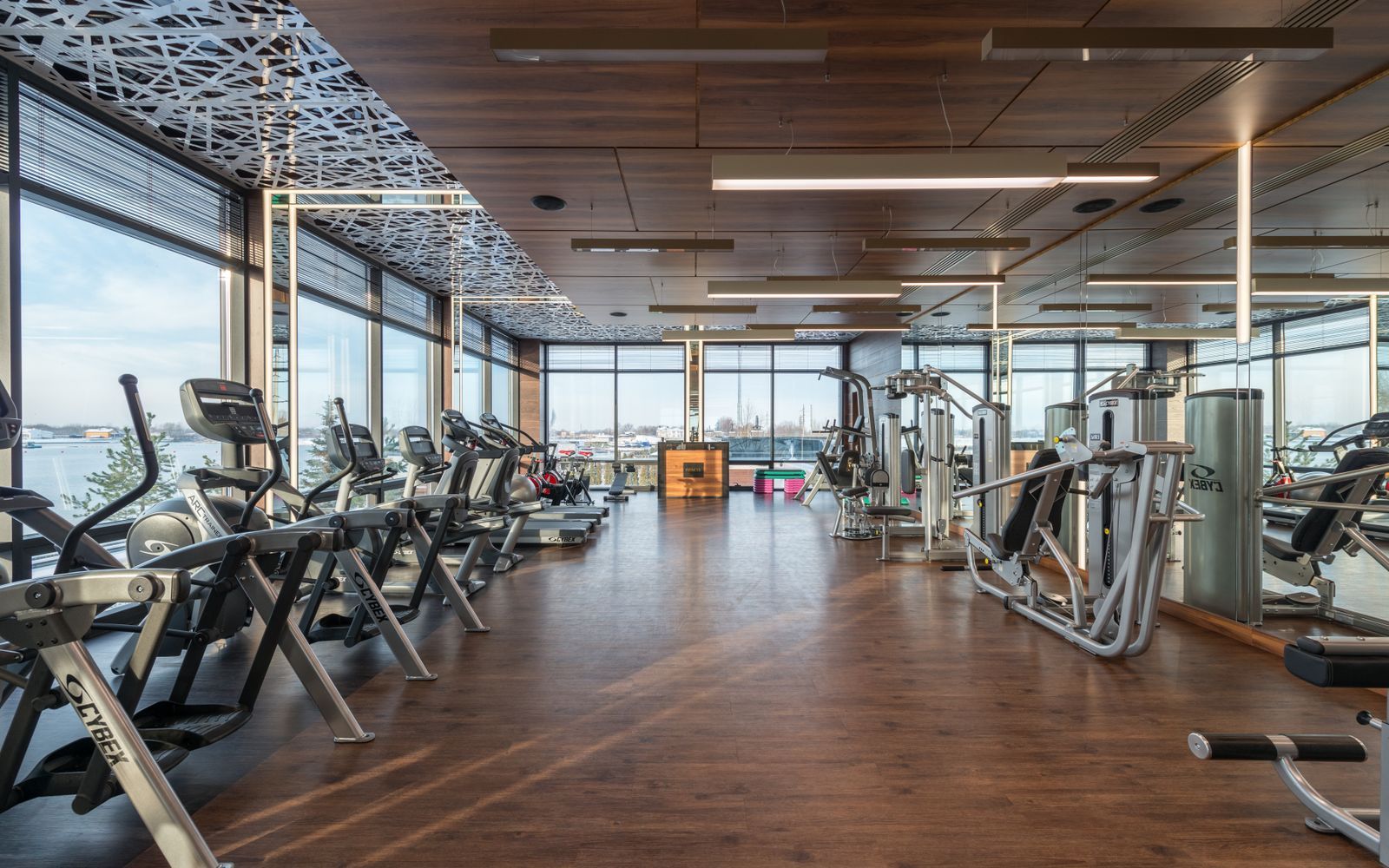 Spacious modern fitness center with cardio equipment by the windows