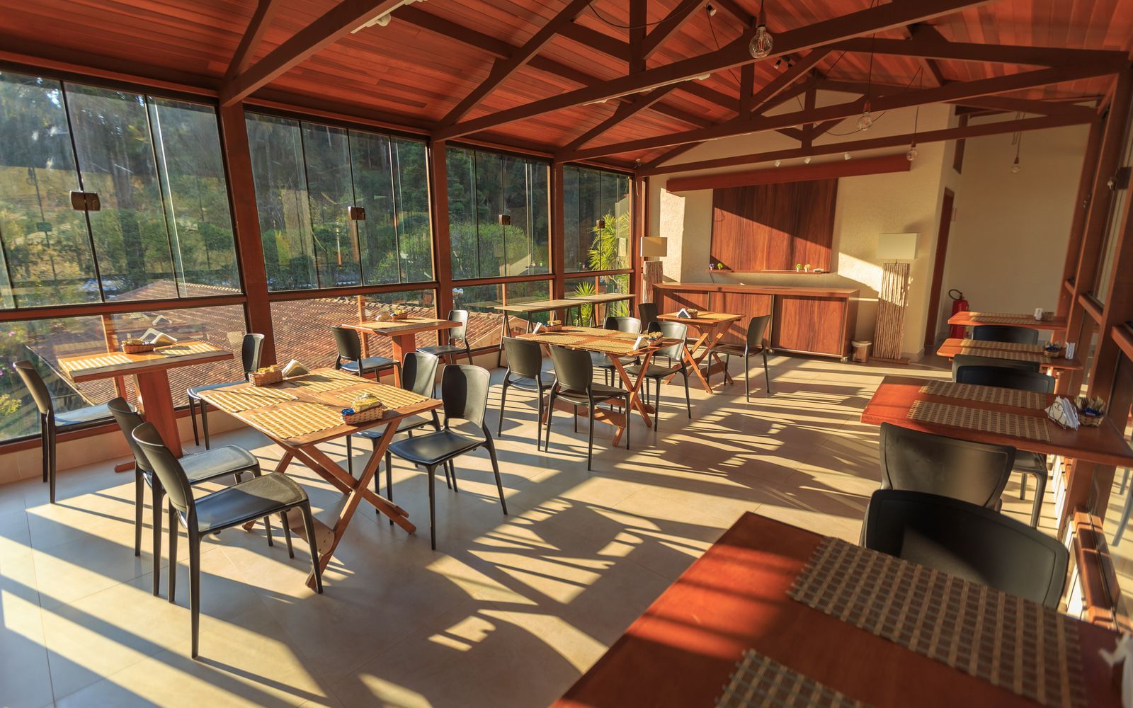 Sunlit restaurant dining room set with wooden tables