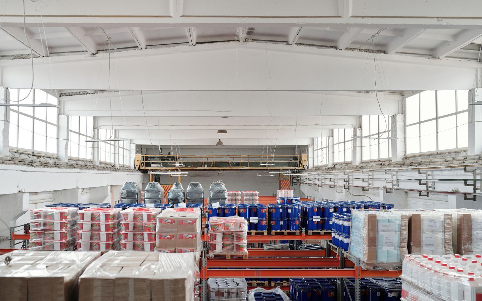 Bright warehouse interior with stacked pallets and racking