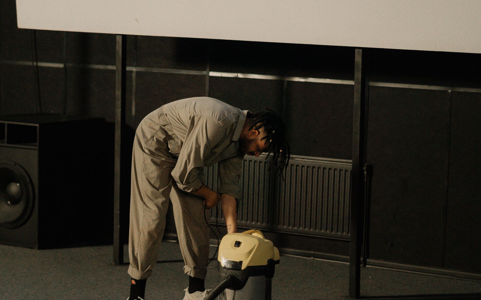 Technician running a commercial vacuum across auditorium carpet